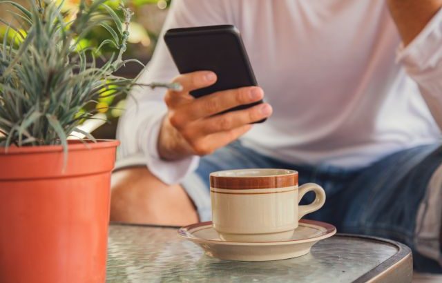 カフェで携帯を触る男性